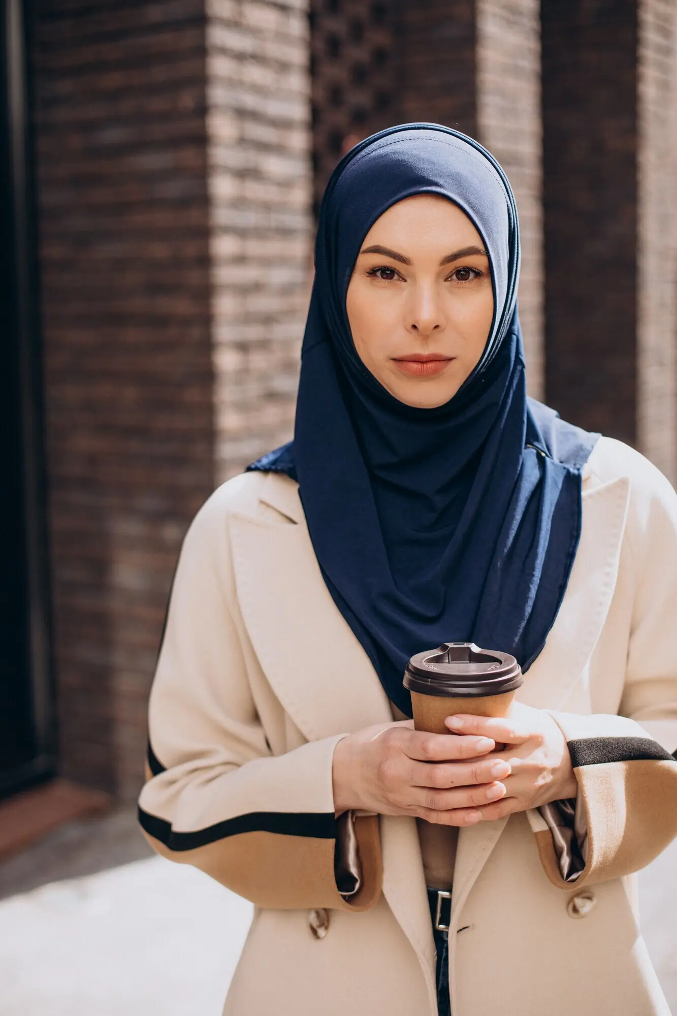 Junge muslimische Frau, die Kaffee trinkt